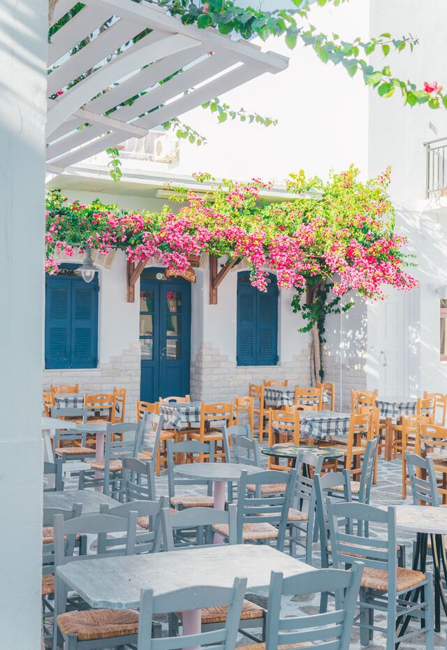Cozy seaside tavern in Antiparos with wooden tables and a view of the Aegean.