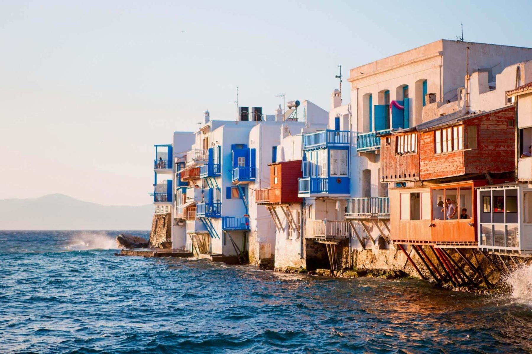 The colorful seaside houses of Little Venice, Mykonos, at sunset.