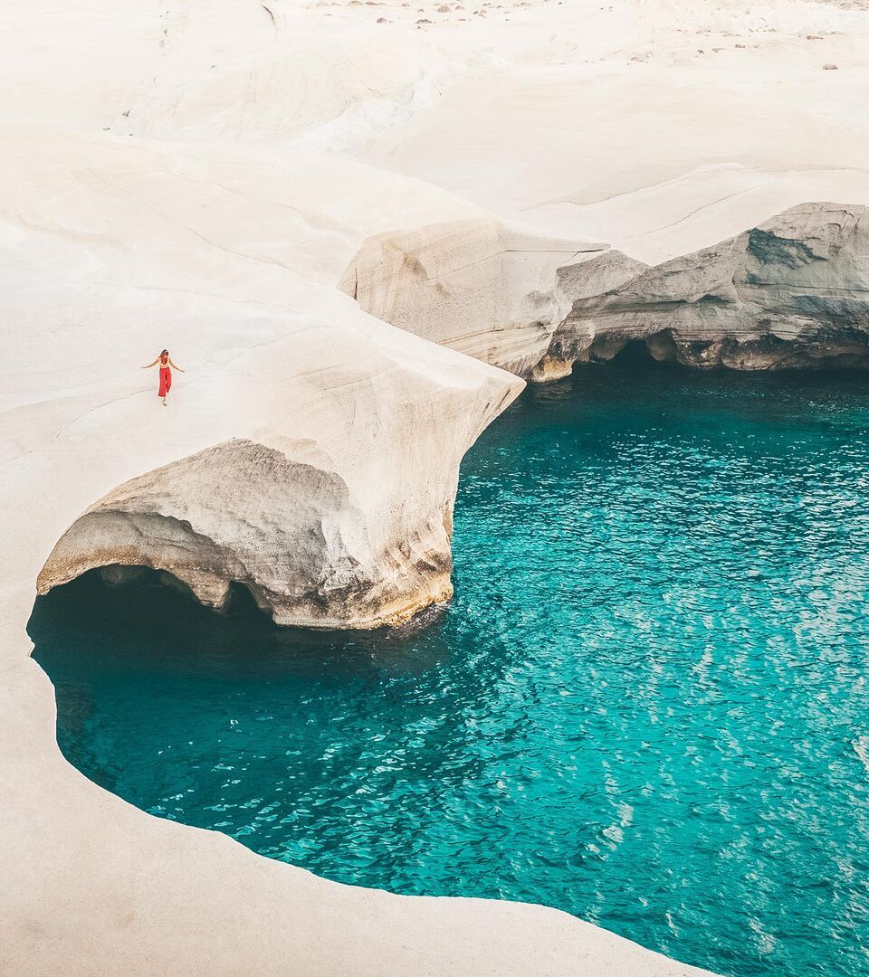 Unique lunar landscape of Sarakiniko Beach in Milos, featuring smooth white rocks and shallow waters