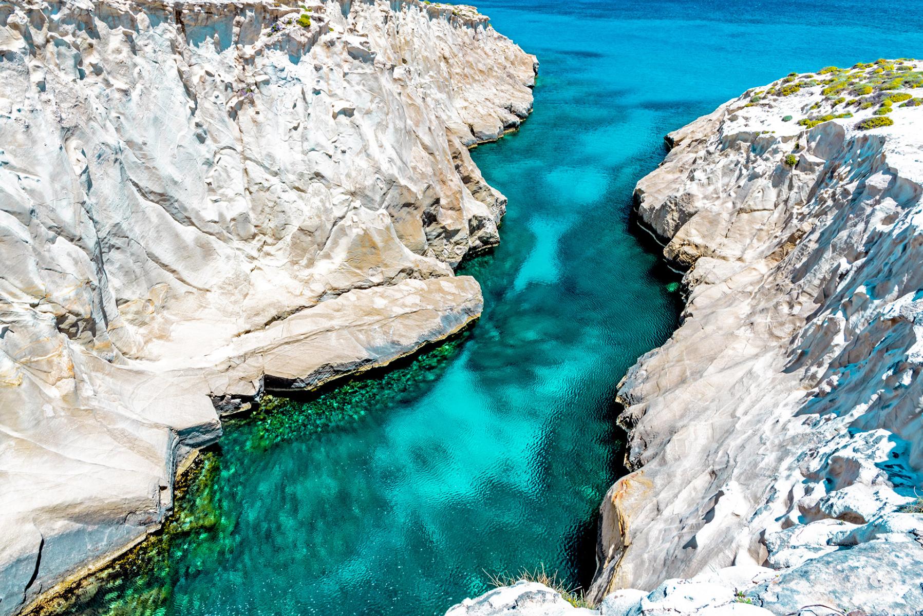 ast landscape of Milos, featuring rocky shorelines, crystal-clear waters, and beautiful natural scenery.