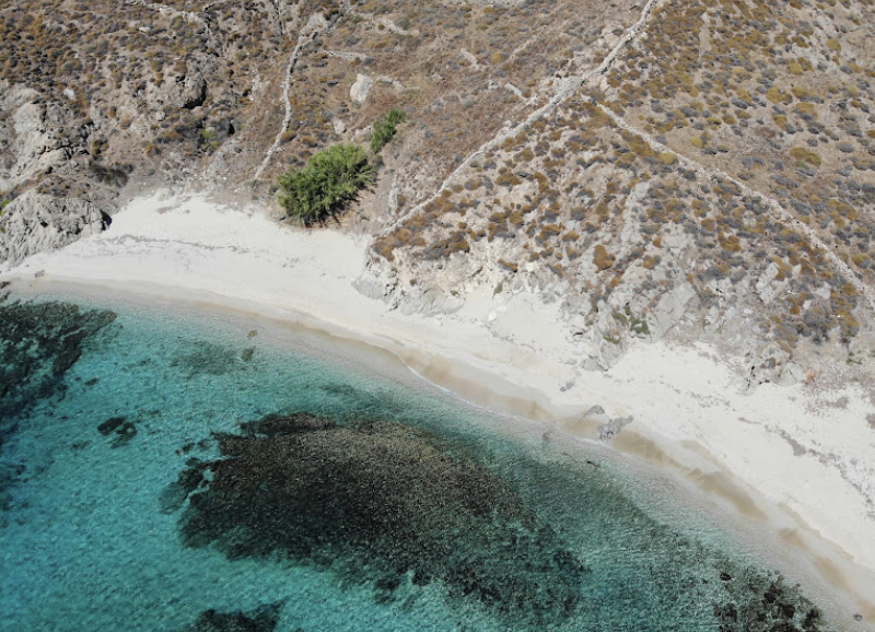 Hidden cove on Mykonos, with pristine sandy shores and crystal-clear waters, far from the crowds.