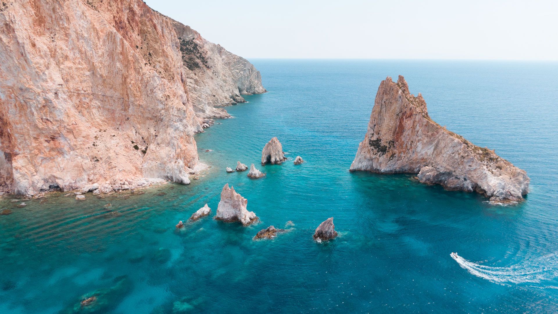 Polyaigos Island's dramatic coastline, with smooth white rocks and deep blue waters meeting in perfect harmony.