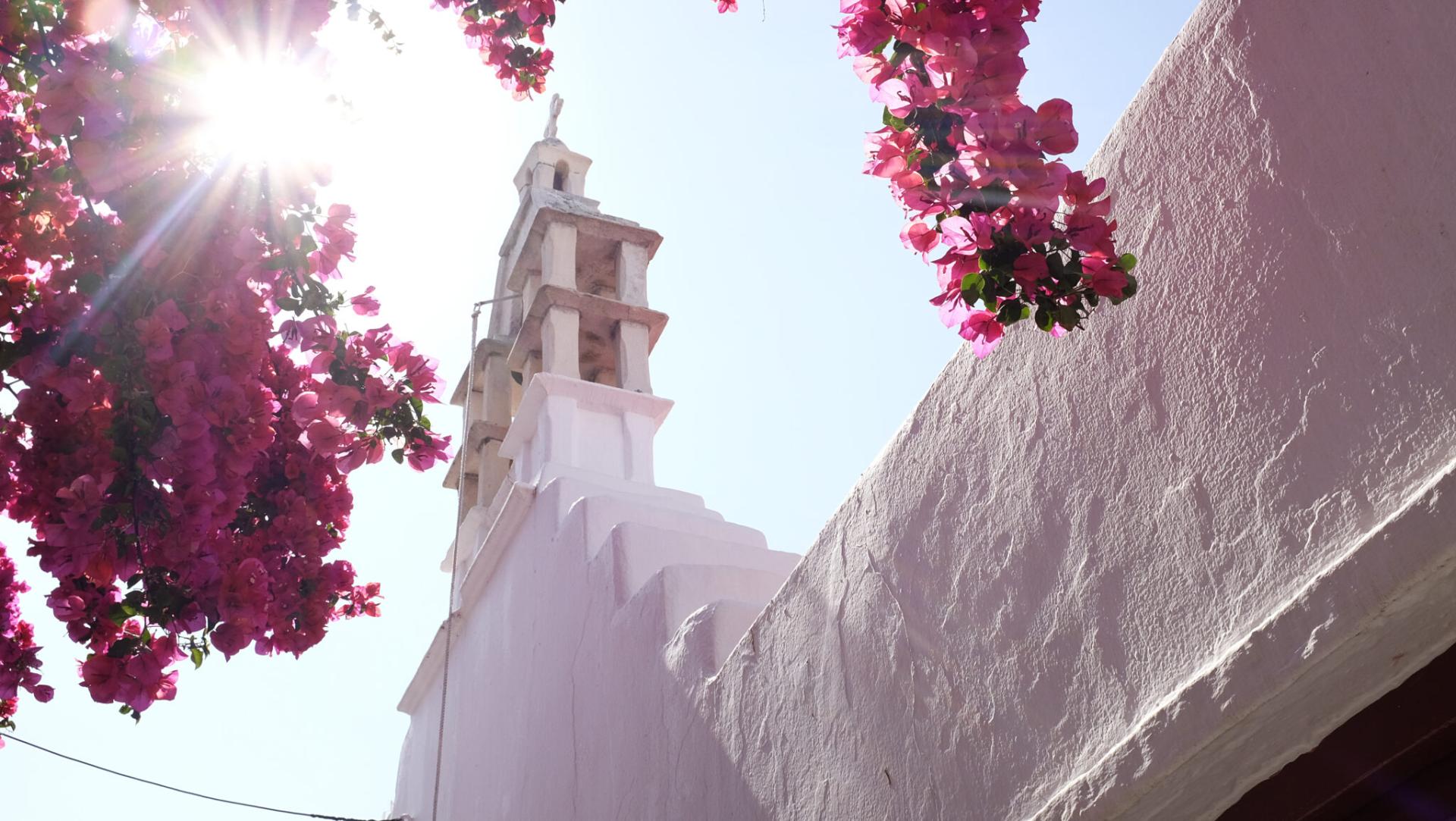 Traditional Cycladic alleys in Mykonos with vibrant bougainvillea.