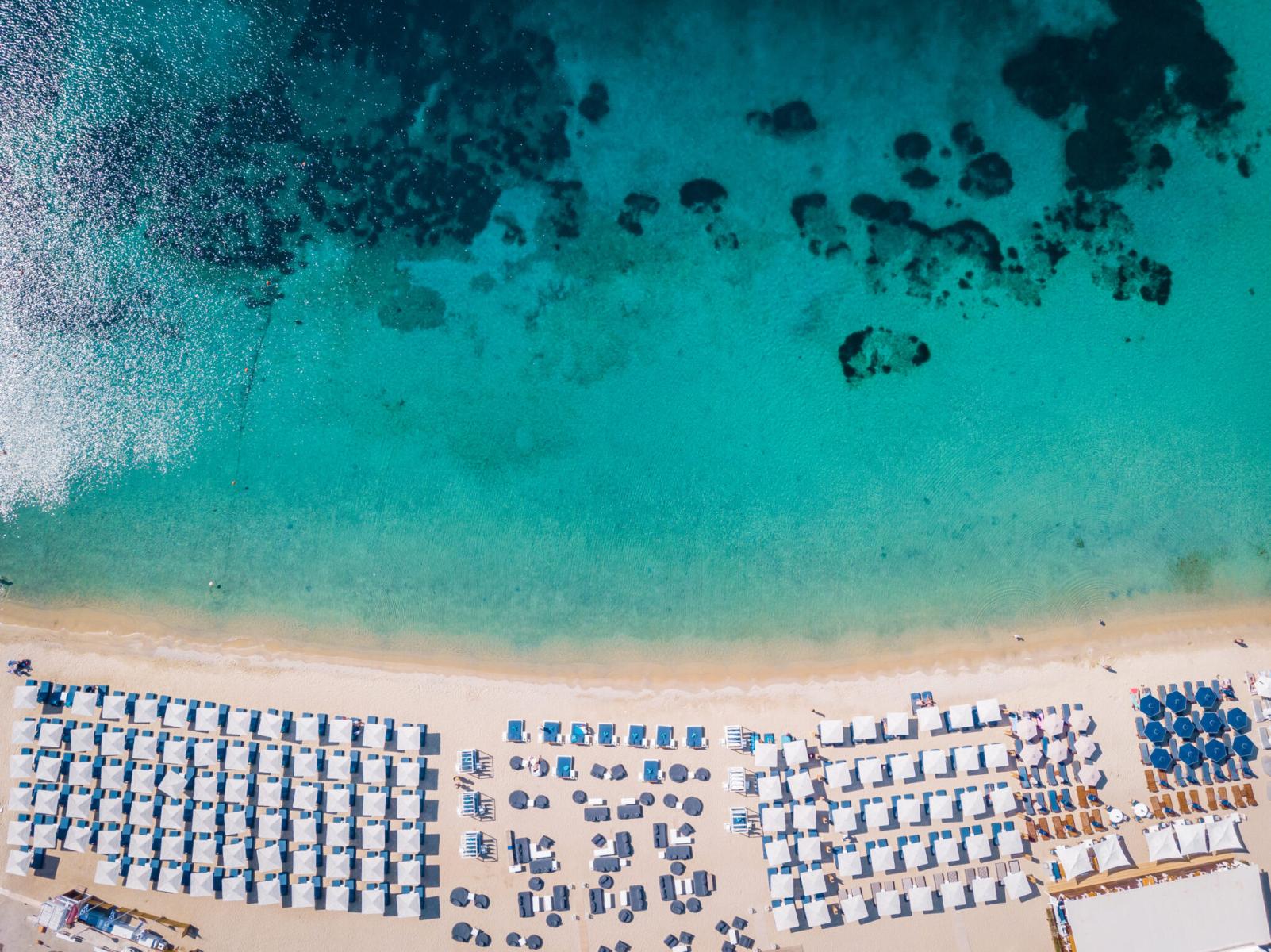 Golden sandy beach on the south coast of Mykonos with crystal-clear waters