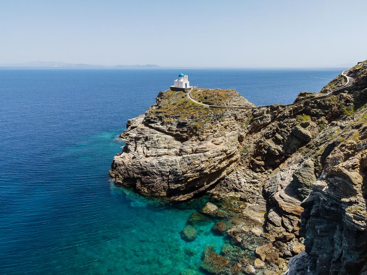 The iconic Church of the Seven Martyrs in Sifnos, perched on a rocky cliff overlooking the Aegean.