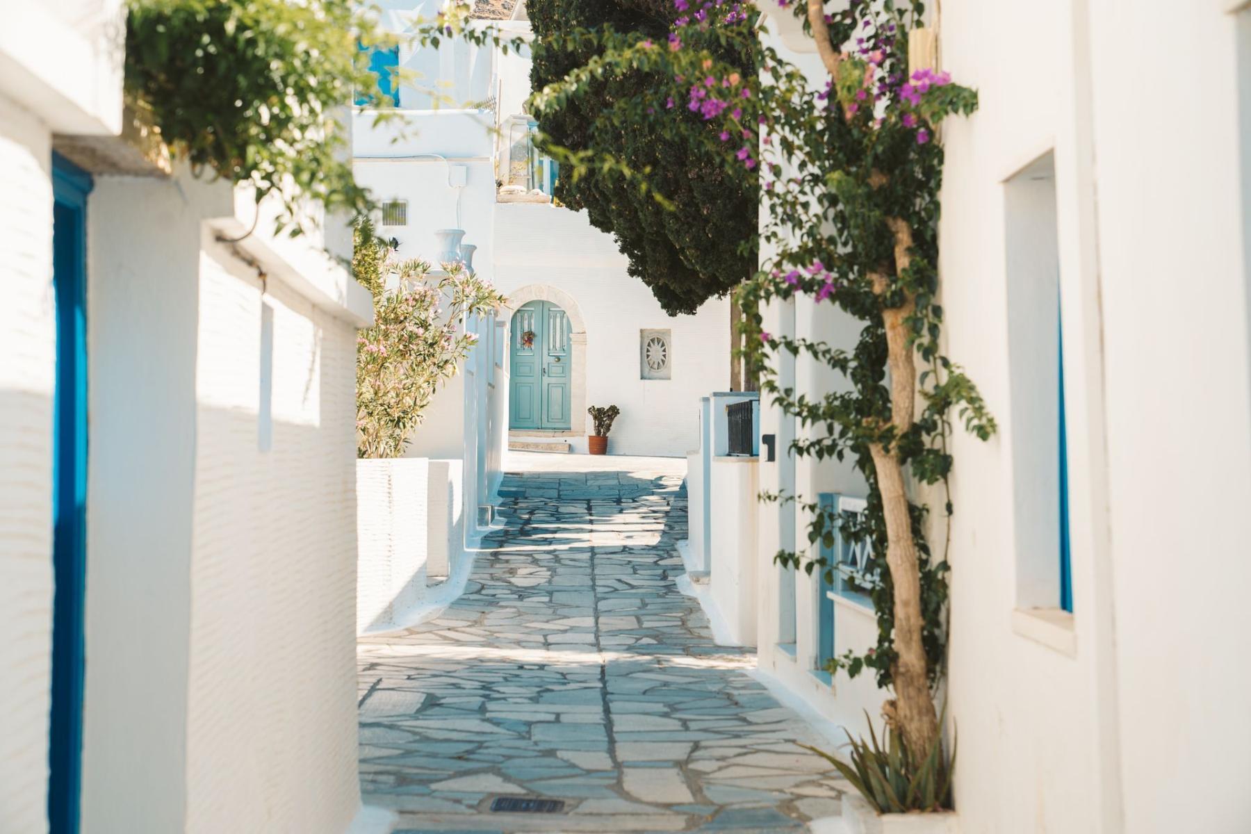 Quiet village street in Tinos with picturesque architecture and blue doors.