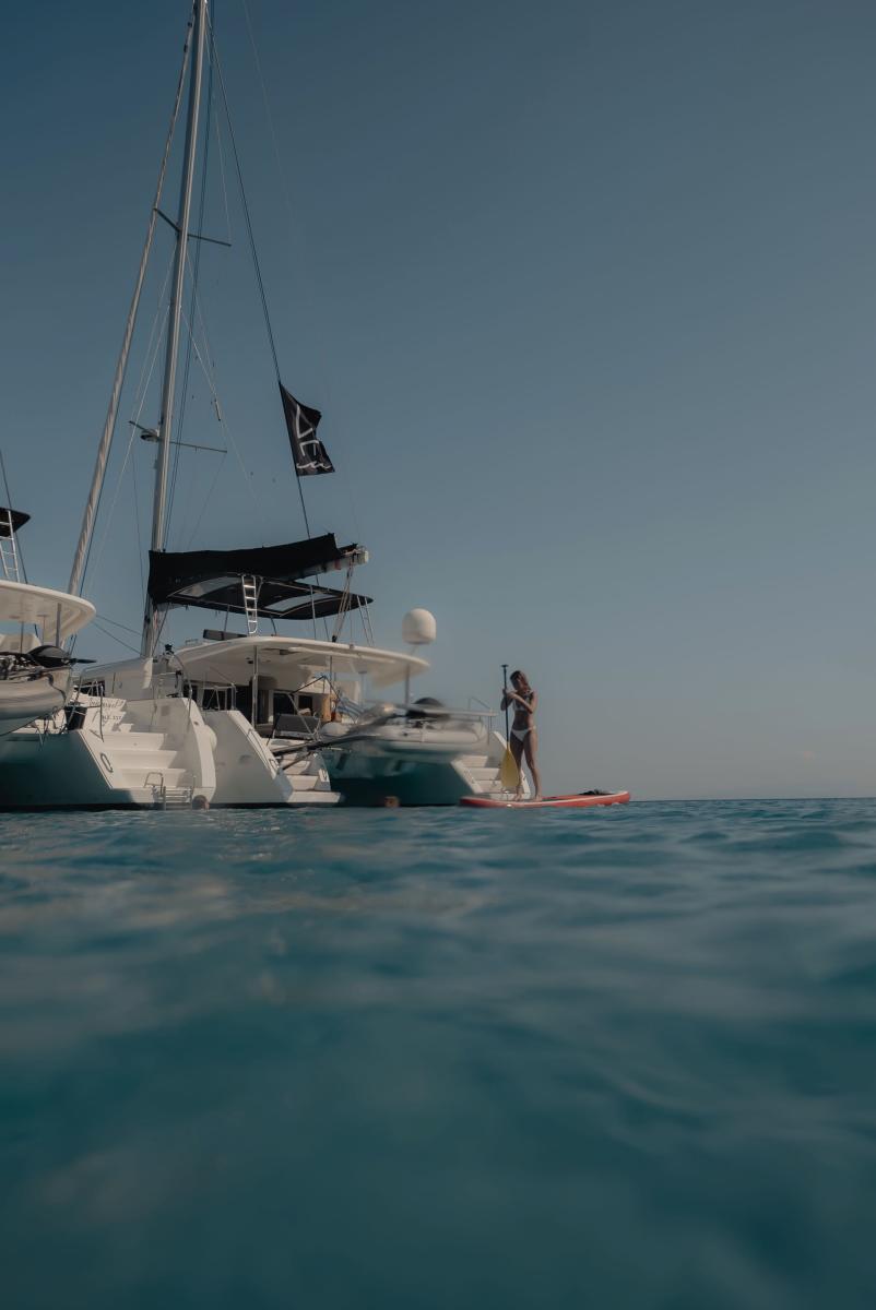 A luxurious catamaran cruising through the crystal-clear waters of Mykonos, offering a premium yacht charter experience.