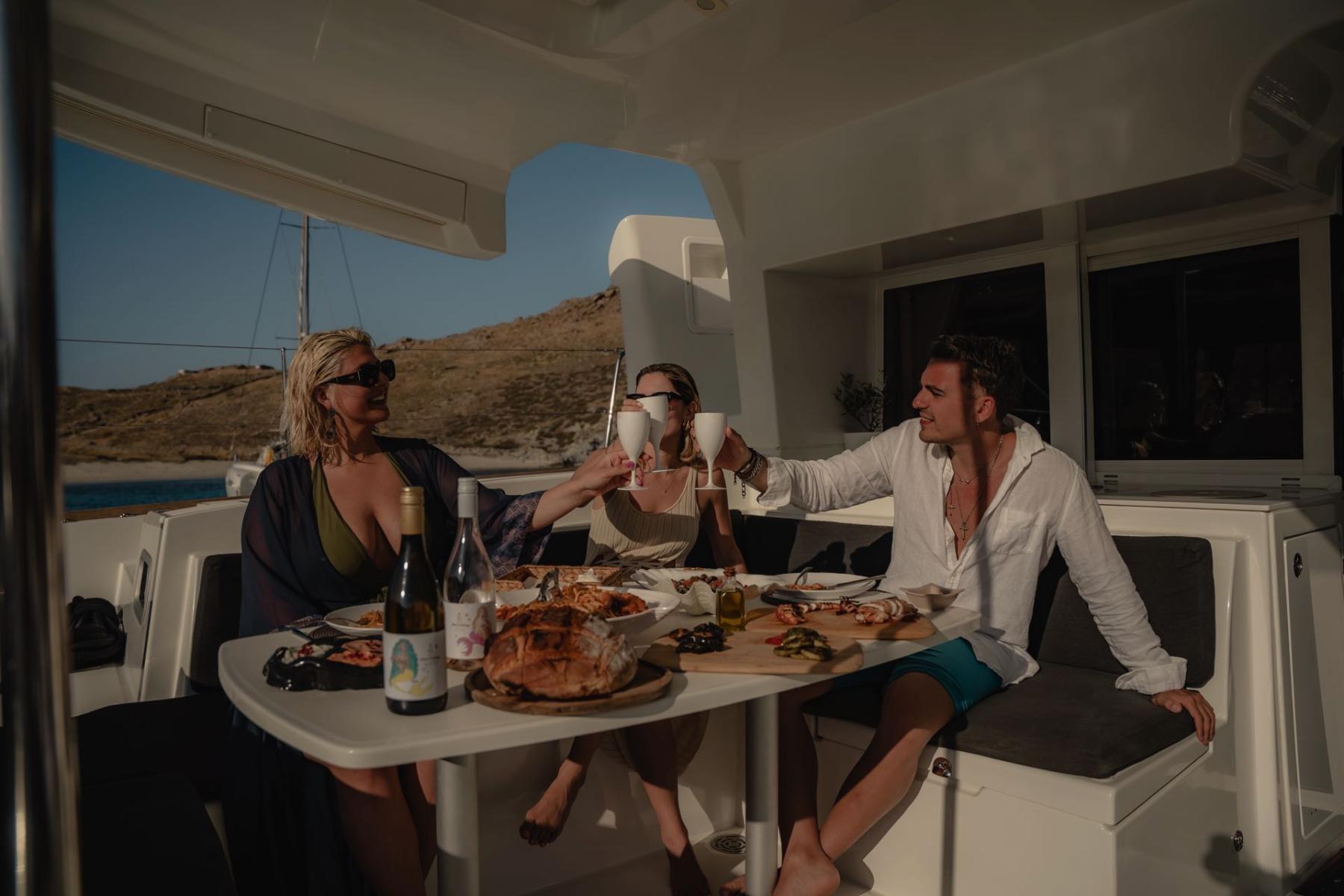 Guests enjoying a delicious seafood meal onboard a luxury yacht while cruising the beautiful Mykonos coastline.