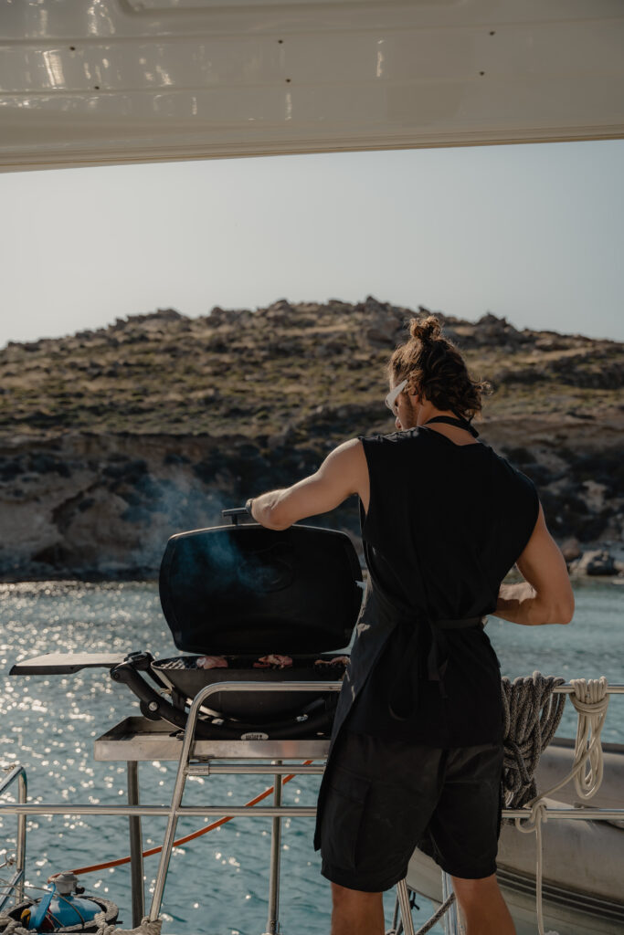The crew expertly preparing a gourmet seafood meal in the galley of a yacht, using the finest ingredients from the sea in Mykonos