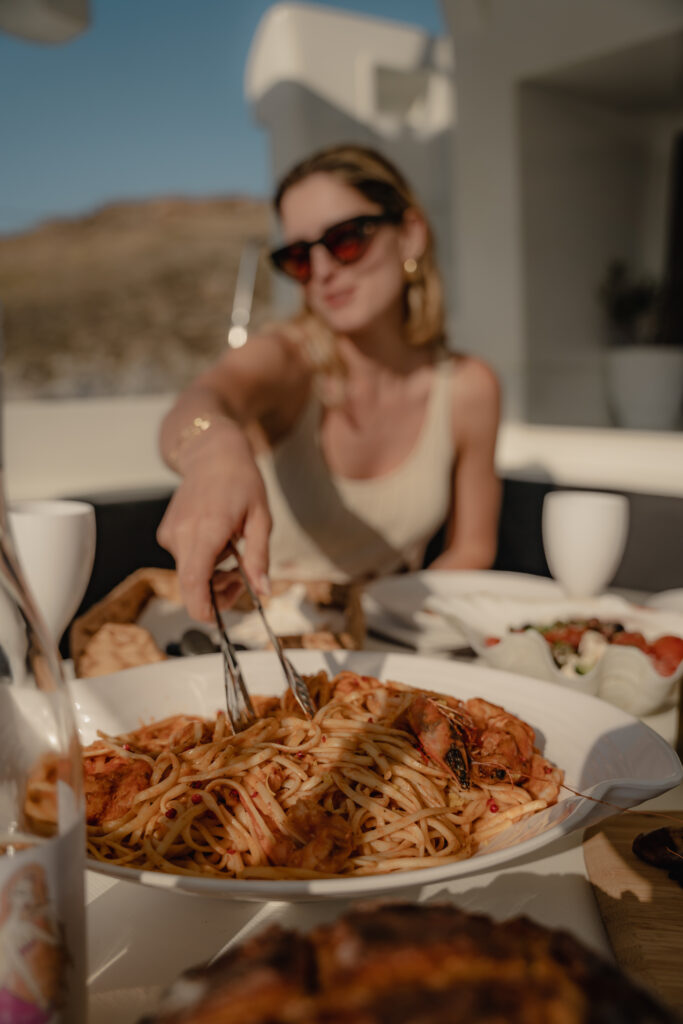 beautifully plated pasta dish made with fresh, local ingredients, served aboard a luxury yacht cruising the waters of Mykonos