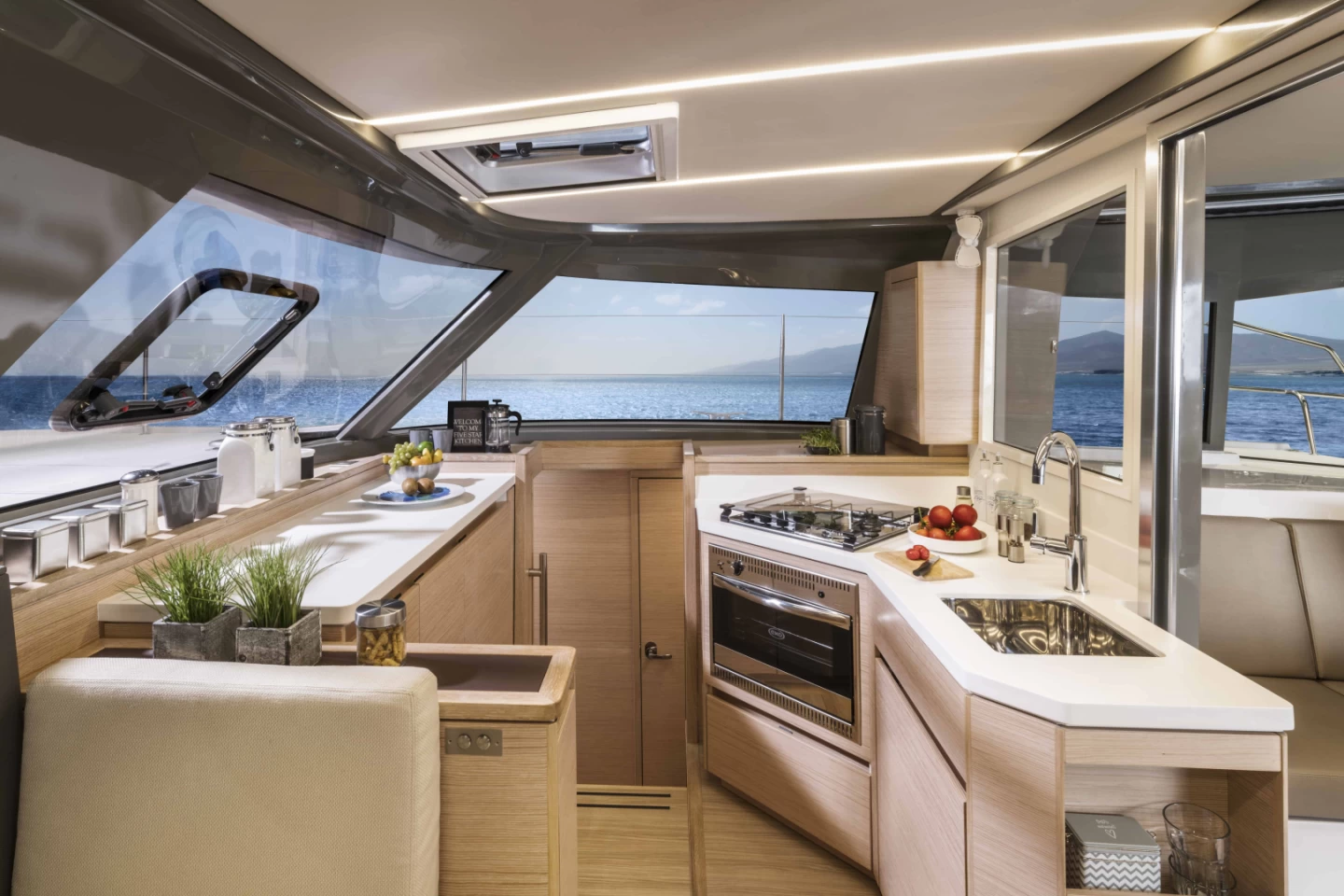 Well-equipped kitchen and dining area inside a luxury catamaran on a Mykonos cruise.