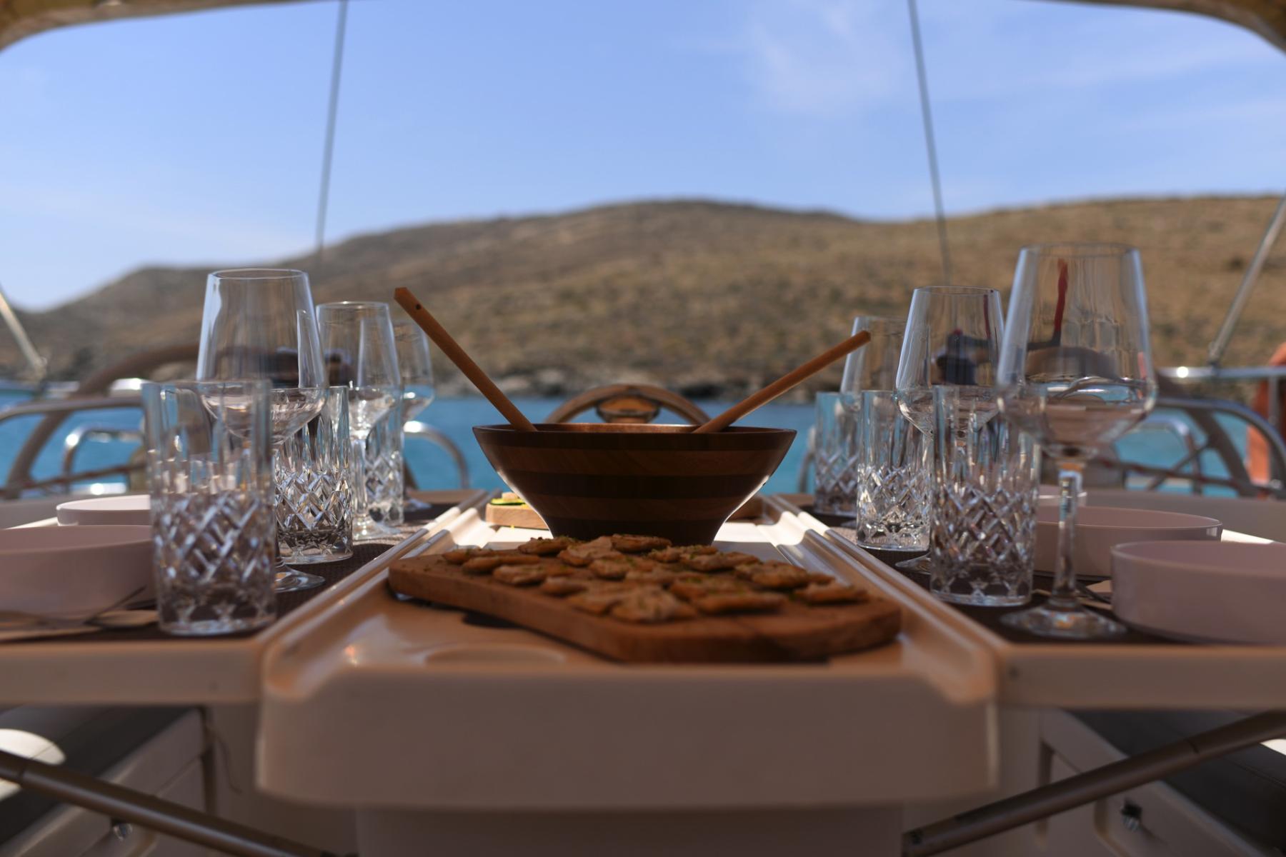 Onboard Dining with Ocean Views in Mykonos – "A beautifully set dining table on the Ocean Star yacht, featuring fresh Mediterranean dishes and a stunning sea backdrop.